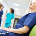 physician burnout: tired doctor in hospital hallway