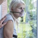 Dying at home: Older woman wearing oxygen mask